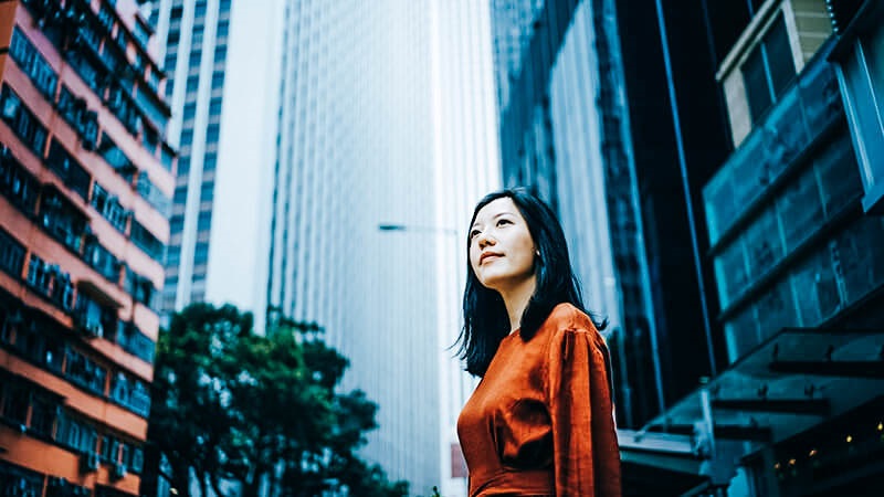woman looking off in front of skyscrapers